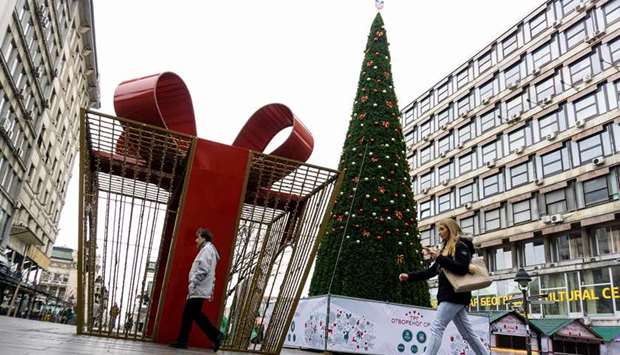 Pedestrians walk past the Christmas tree in central Belgrade that has sparked controversy as its price, u20ac83,000, makes it one of the most expensive in the world.