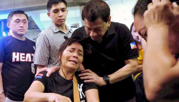 Philippines' President Rodrigo Duterte (2nd R) comforting a relative of one of the victims after a fire engulfed a shopping mall in Davao City on the southern Philippine island of Mindanao