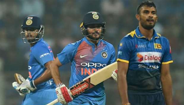 Indian batsmen Manish Pandey (C) and Shreyas Iyer (L) run between the wickets during the third T20 international cricket match