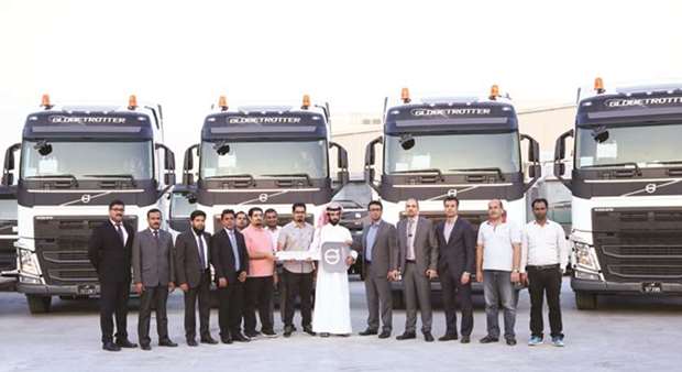 Domasco executives line up in front of the Volvo FH Globetrotter trucks.