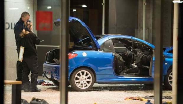 Police officers inspect damage in the lobby of the German Social Democratic Party (SPD) headquarters after a car was used to ram the building in Berlin