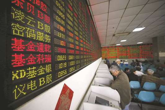 Investors look at computer screens showing stock information at a brokerage house in Shanghai. The Shanghai Composite index closed down 16.22 points to 3,280.84 yesterday.