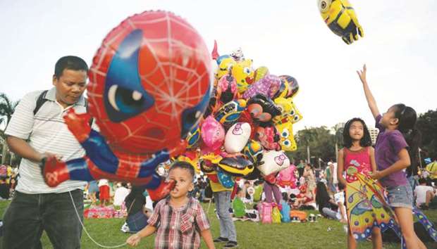 Children play with toy balloons at a park in Manila on Christmas Day yesterday.