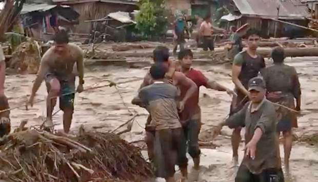 People attempt to rescue flood victims in Lanao Del Norte, Philippines.
