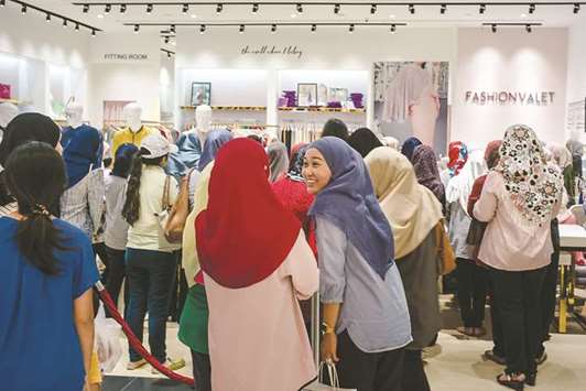 Customers watch a styling session at the FashionValet store in Kuala Lumpur (file). Halal certification will be part of Malaysiau2019s digital framework to ensure Shariah compliance and authenticity of halal products and services, which can comprise all segments of the Islamic economy, including Islamic finance, halal food, halal tourism, halal pharmaceuticals and cosmetics, and halal fashion.
