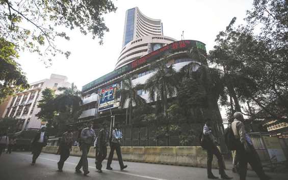 People walk by the Bombay Stock Exchange building in Mumbai. The Sensex advanced 0.2% to an all-time high of 34,010.61 points yesterday.