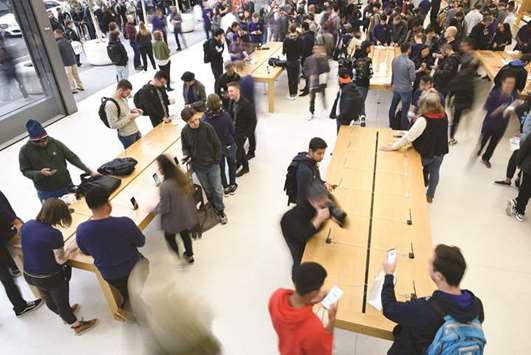 Employees assist customers with iPhone X smartphones during the sales launch at a store in San Francisco on November 3, 2017. Analysts lowered iPhone X  shipment projections for the first quarter of next year, citing signs of lacklustre demand at the end of the holiday shopping season, and the companyu2019s shares fell  yesterday along with those of some suppliers.