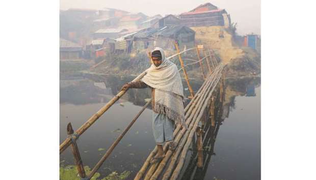 A Rohingya refugee crosses a bridge in the early morning at the Balukhali refugee camp near Coxu2019s Bazar yesterday.
