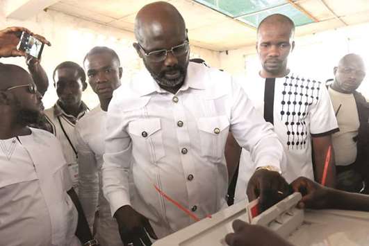 Football icon and candidate for the presidential election for the Coalition for Democratic Change (CDC), George Weah casts his ballot for the second round of elections at a polling station in Monrovia, yesterday.