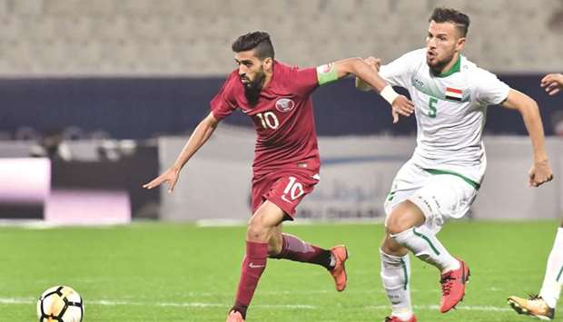 Qataru2019s forward and captain Hassan al-Haydos gets past Iraq defender Ali Faez (right) during the Gulf Cup match at Al Kuwait Sports Club Stadium in Kuwait City yesterday. (AFP)
