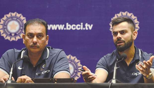Indian captain Virat Kohli (right) speaks as coach Ravi Shastri looks on during a news conference in Mumbai yesterday. (AFP)