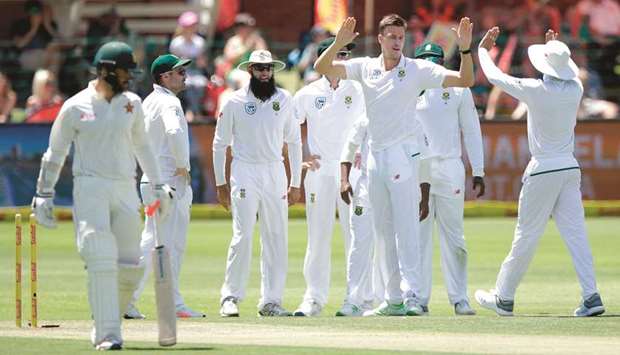 South African bowler Morne Morkel (second from right) celebrates with teammates after taking the wicket of Zimbabweu2019s Ryan Burl (left) on second day of the four-day Test in Port Elizabeth, South Africa, yesterday. (AFP)