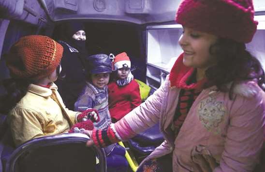 Syrian children sit in an ambulance during an evacuation operation by the International Committee of the Red Cross in Douma in the eastern Ghouta region on the outskirts of Damascus.
