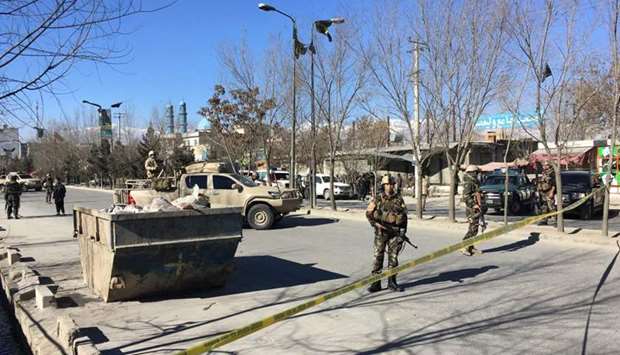 Afghan security forces stand guard near the site of multiple blasts in Kabul