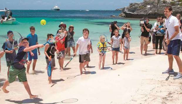 Switzerlandu2019s Roger Federer gives local children a tennis lesson on a beach at Rottnest Island off the coast of Western Australia yesterday. (AFP)