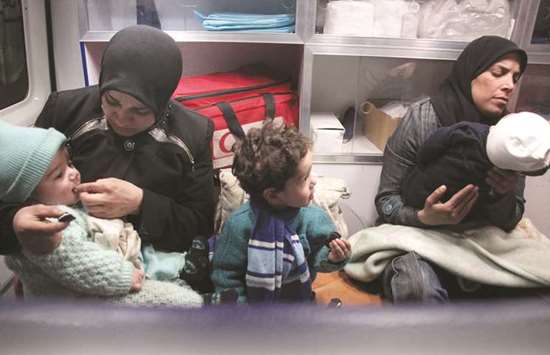 Syrian paramedics and civilians sit inside an ambulance on the second night of an evacuation operation led by the Syrian Red Crescent and the International Committee of the Red Cross in Douma in the eastern Ghouta region on the outskirts of the capital Damascus.