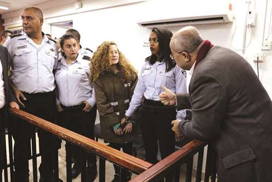 Ahmed Tibi, an Arab member of the Israeli parliament (right), gestures as he chats with Palestinian teen Ahed Tamimi (centre) at the military court in Ofer Prison near the West Bank city of Ramallah.