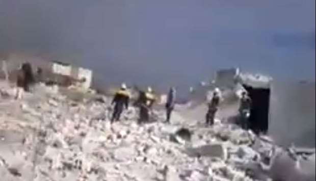 People inspect the remnants of a building destroyed in an airstrike in Idlib - image grab from a video posted on Twitter.
