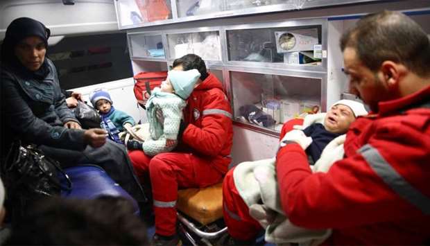 Woman is seen with her children in an ambulance during medical evacuation from the besieged town of Douma, Eastern Ghouta