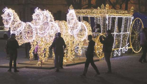 Above: People are seen yesterday near decorations for the New Year in Sevastopol, Crimea.