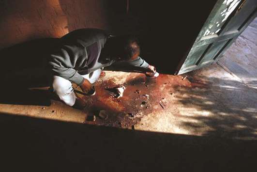 One day after the raid on the school, a worker cleans up stains at the Agriculture  Training Institute in Peshawar.