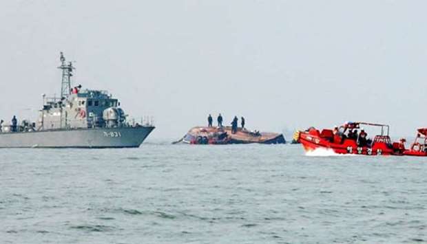 South Korean coastguard members search for missing persons after a fishing boat (centre) crashed with a fuel tanker at sea near the western port city of Incheon on Sunday.