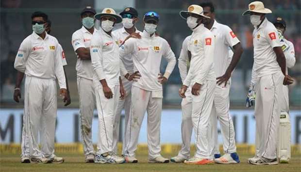 Sri Lanka cricket players wear masks during the second day of the third Test against India at the Feroz Shah Kotla in New Delhi on Sunday.
