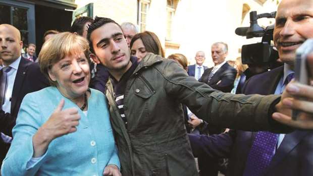 A Syrian refugee takes a selfie with German Chancellor Angela Merkel in Berlin, in this September 2015 file picture.