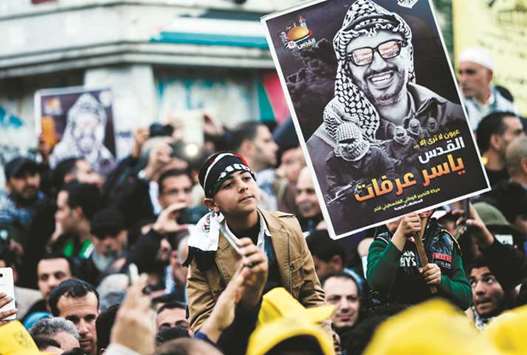 Supporters of the Fatah movement hold up a portrait of late Palestinian leader Yasser Arafat during a rally in Gaza City yesterday, marking the 53rd anniversary of the creation of the political party.