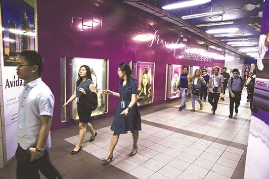 Commuters walk through an underpass in the Makati district of Manila (file). The first of several tax reforms planned by Duterteu2019s economic team would lower personal income tax, while raising levies on oil, vehicles and sugary drinks to yield additional revenue of at least 100bn pesos ($2bn) in the first year.
