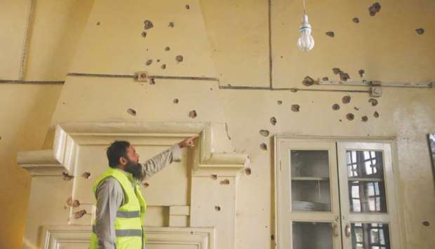 This picture taken in the aftermath of the attack on Friday morning shows a rescue worker gesturing toward bullet holes in the wall of a computer lab at the Agriculture Training Institute in Peshawar.
