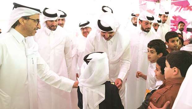 His Highness the Emir Sheikh Tamim bin Hamad al-Thani interacts with children during his visit to the 28th Doha International Book Fair at Doha Exhibition and Convention Centre yesterday. HE the Minister of Culture and Sports Salah bin Ghanem bin Nasser al-Ali is also seen.