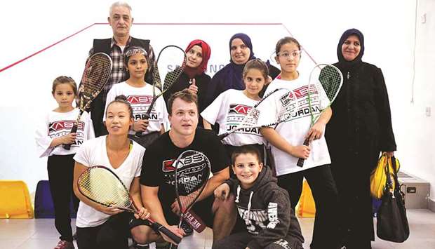 US charity Reclaim Childhoodu2019s Clayton Keir (centre) poses with Syrian refugee girls and their parents during a squash training session in Amman on November 18, 2017. (AFP)