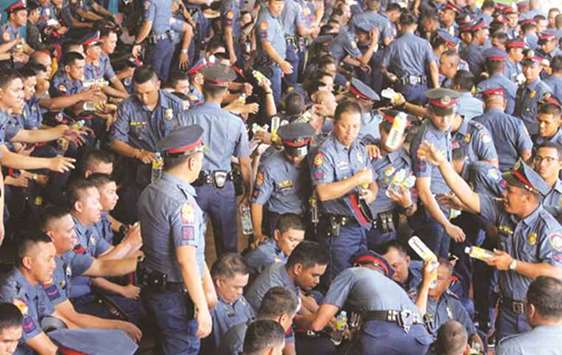 Caloocan policemen gather at the grandstand in Camp Crame, the headquarters of the Philippine National Police, during the closing rites of the reformation and re-orientation programme.