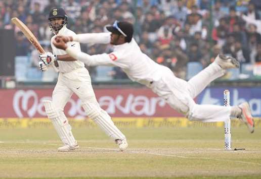 Sri Lanka's Dhananjaya de Silva fields as Indian batsman Shikhar Dhawan (left) looks on during the fourth day of the third Test at the Feroz Shah Kotla Cricket Stadium in New Delhi yesterday. (AFP)
