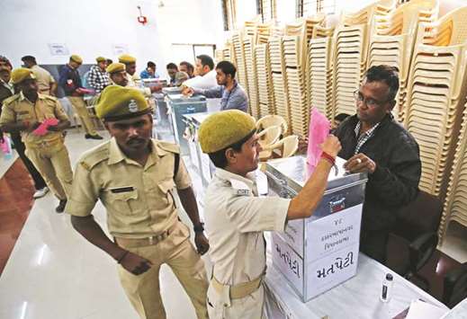 A policeman casts his postal ballot at a polling station ahead of Gujarat Assembly elections, in Ahmedabad.