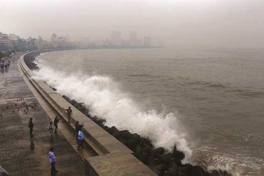 People take photographs of a large wave caused by Cyclone Ockhi in Mumbai yesterday.