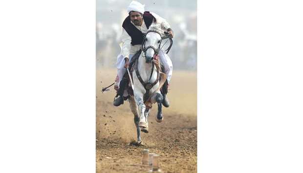 This photograph taken on November 7 shows a horseman charging with a lance to pick up pegs at the tent-pegging competition during an annual festival at Kot Fateh Khan.