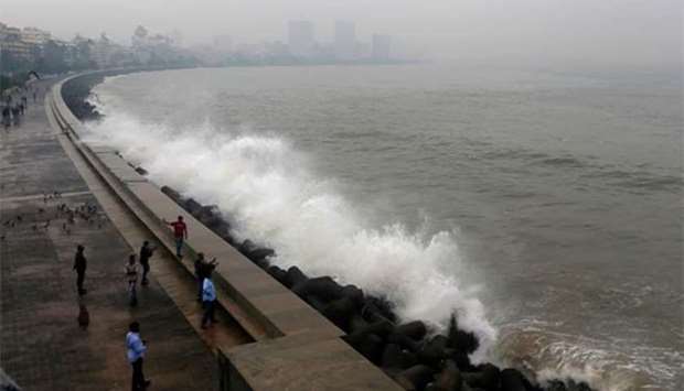 People take photographs of a large wave caused by Cyclone Ockhi in Mumbai on Tuesday.