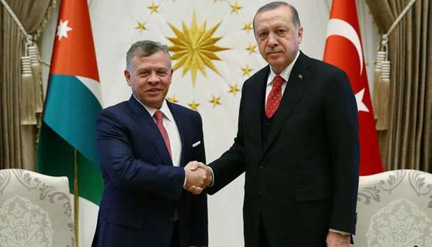 Turkish President Recep Tayyip Erdogan (R) shaking hands with King Abdullah II of Jordan during a meeting at the presidential palace in Ankara.