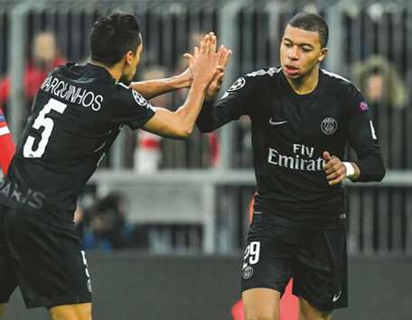 Paris Saint-Germainu2019s French forward Kylian Mbappe (right) celebrates with Marquinhos after scoring against Bayern Munich during the UEFA Champions League match in Munich, southern Germany, on Tuesday night. (AFP)