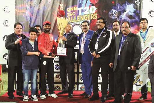 Indian ambassador to Qatar P Kumaran presents the winnersu2019 trophy to Tuskers CC captain Aneesh Kakkot after they beat Warriors CC in the final of the Qatar National Bank-Indian Sports Centre T-20 First All Indian Teams Hard Ball Cricket Tournament at Asian Town Cricket Stadium.