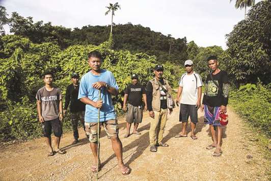 File photo shows Efren u201cTatau201d Balladares (third left), one of the leaders of the Palawan NGO Network Inc (PNNI), standing in front of other para-enforcers from the group on the outskirts of a forest near the tourist town of El Nido on Palawan island.