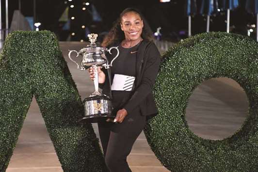 This file photo taken on January 29, 2017 shows Serena Williams of the US posing with the championship trophy after her victory against Venus Williams of the US in the womenu2019s singles final at the Australian Open in Melbourne. (AFP)