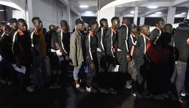 Returnees queue to be attended to by state officials after alighting from chartered aircraft that brought home 150 migrants from Libya