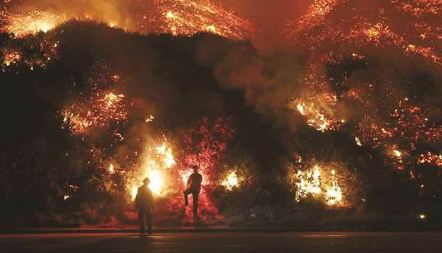 Firefighters monitor a section of the Thomas Fire along the 101 freeway north of Ventura, California.