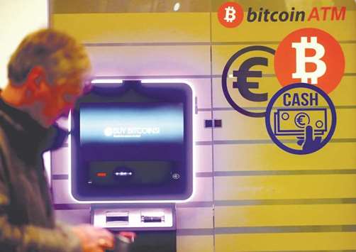 A man walks past a bitcoin ATM in Vilnius, Lithuania yesterday. Bitcoin, which is not traded on traditional currency market, powered to a fresh high of $15,969.99, before falling back according to Bloomberg data.