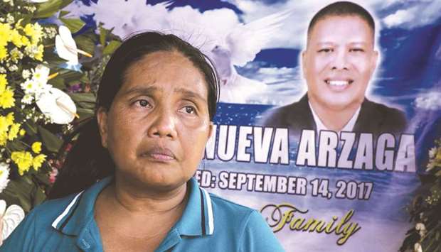 A September 27, 2017, photo of Adelita Arzaga, widow of murdered environmental para-enforcer and PNNI member Ruben Arzaga, sitting in front of a poster for her murdered husband in the tourist town of El Nido, on Palawan island in the Philippines.
