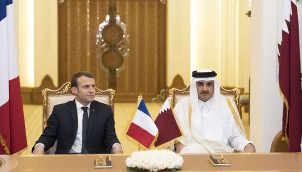 His Highness the Emir Sheikh Tamim bin Hamad al-Thani and French President Emmanuel Macron (L)