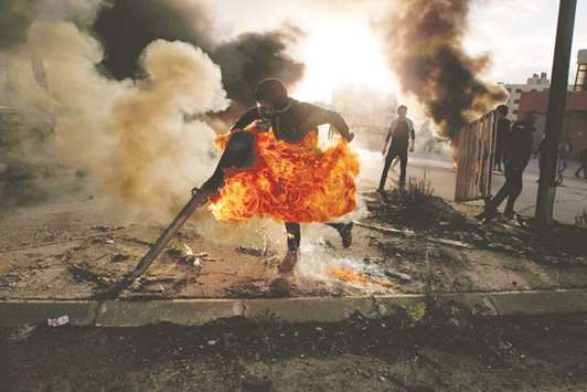 A Palestinian protester on fire during clashes with Israeli troops near the West Bank city of Ramallah.